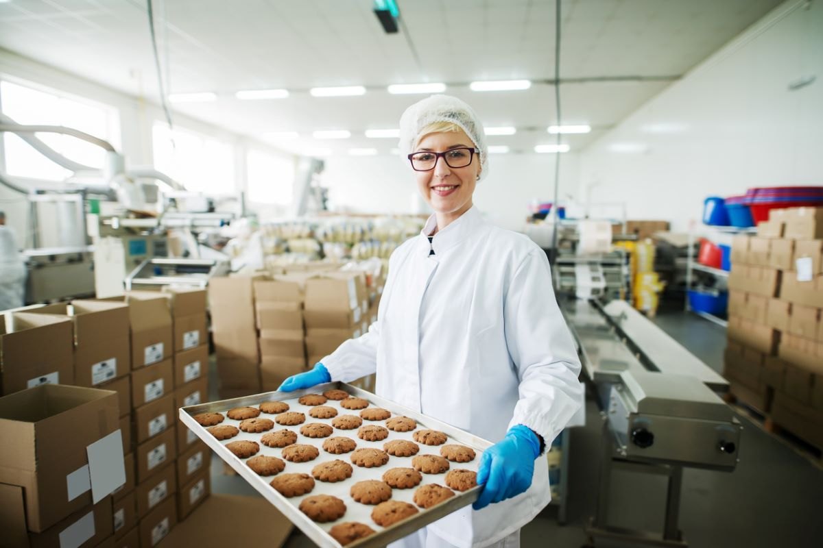 Employée de l'industrie agroalimentaire montrant fièrement ses cookies